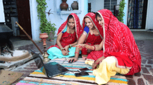 Women use a laptop in a household in India. Women cook food and learn technology. Rural women using Laptop.