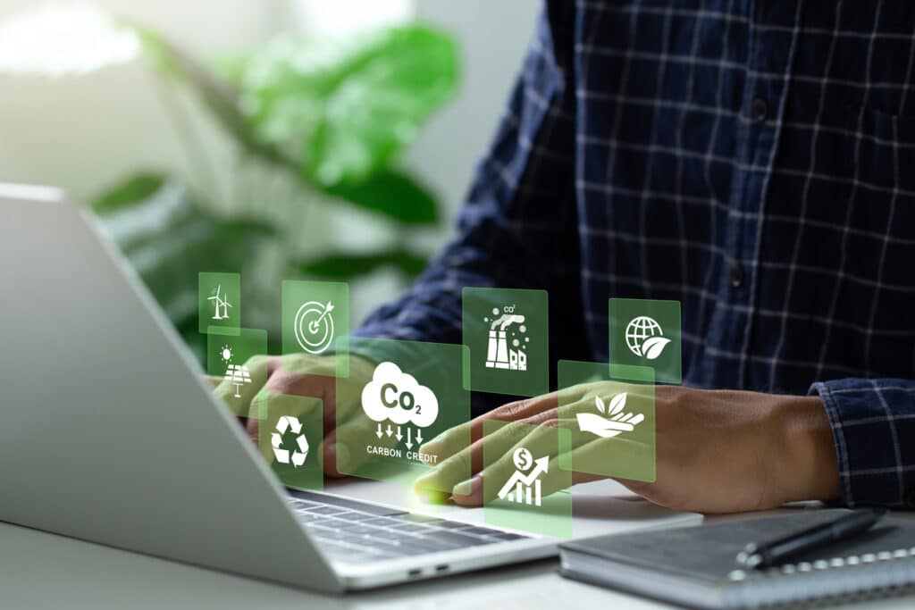 Man using a laptop to trade carbon credit on a virtual screen.