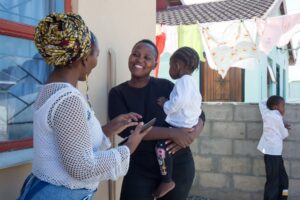 A mother holds her toddler an smiles while being interviewed in Cape Town, South Africa.