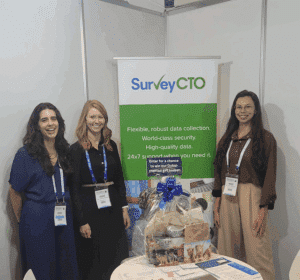 Three women from SurveyCTO at their table in DIHAD